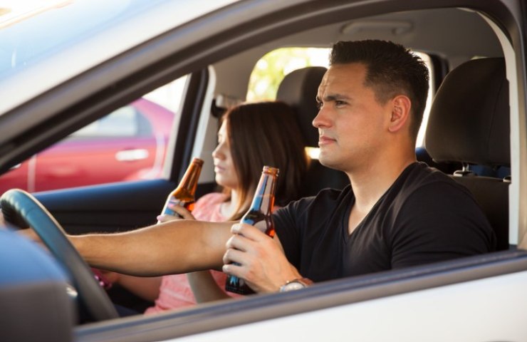 Guidatore e passeggero bevono una birra in macchina