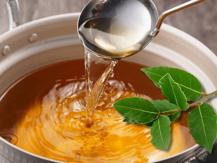 pentola con brodo e foglia di alloro in evidenza