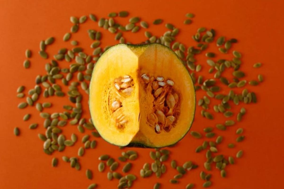 Zucca aperta a metà con tutti i semi sparsi su una superficie 