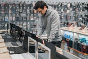 Ragazzo guarda PC nel negozio di elettronica
