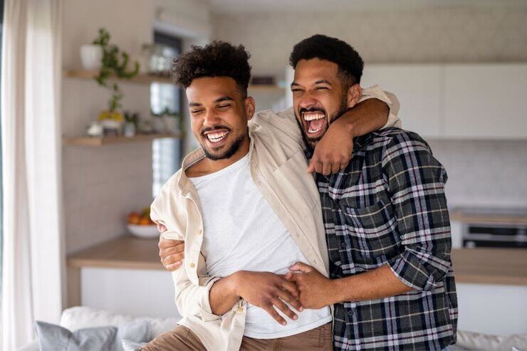 Due uomini si abbracciano sorridenti 