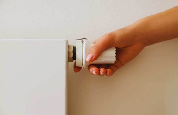 mano sulla valvola del termosifone