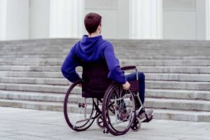 ragazzo sulla sedia a rotelle di fronte a una scalinata
