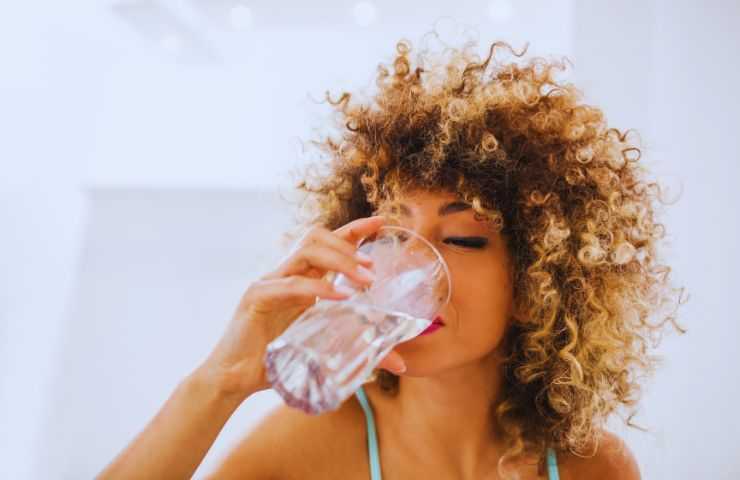 ragazza beve bicchiere d'acqua