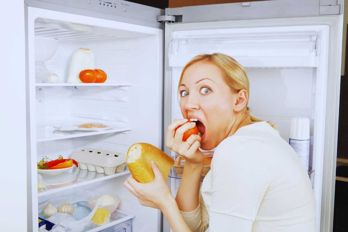 ragazza mangia nel frigo