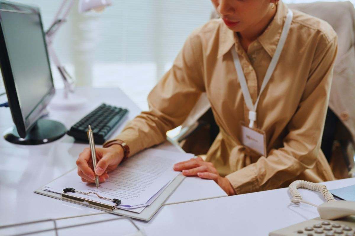 persona che scrive su dei fogli