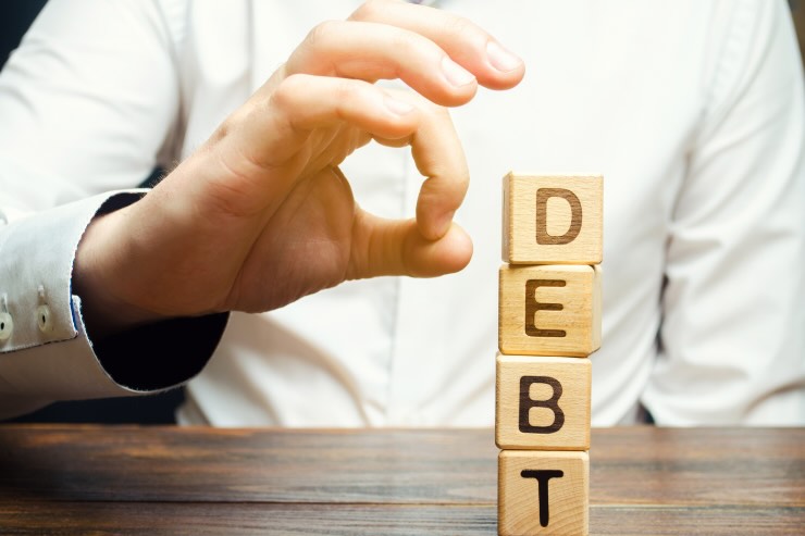 mano che butta giù scritta debt