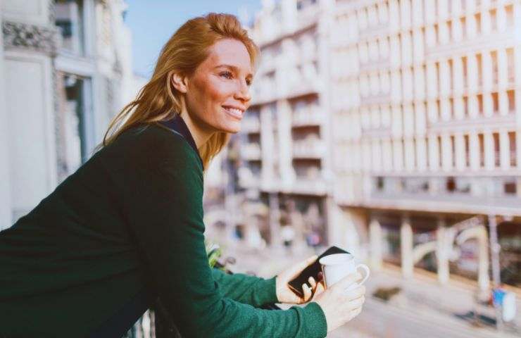 donna sorridente affaccia al balcone