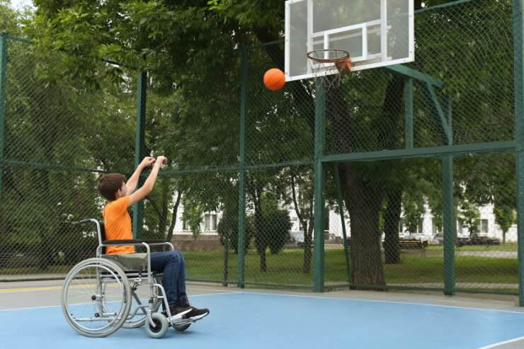 ragazzo disabile che fa canestro