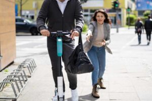Donna rincorre monopattino con il suo zaino
