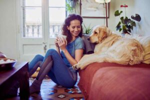 ragazza con una bevanda e cane sul divano