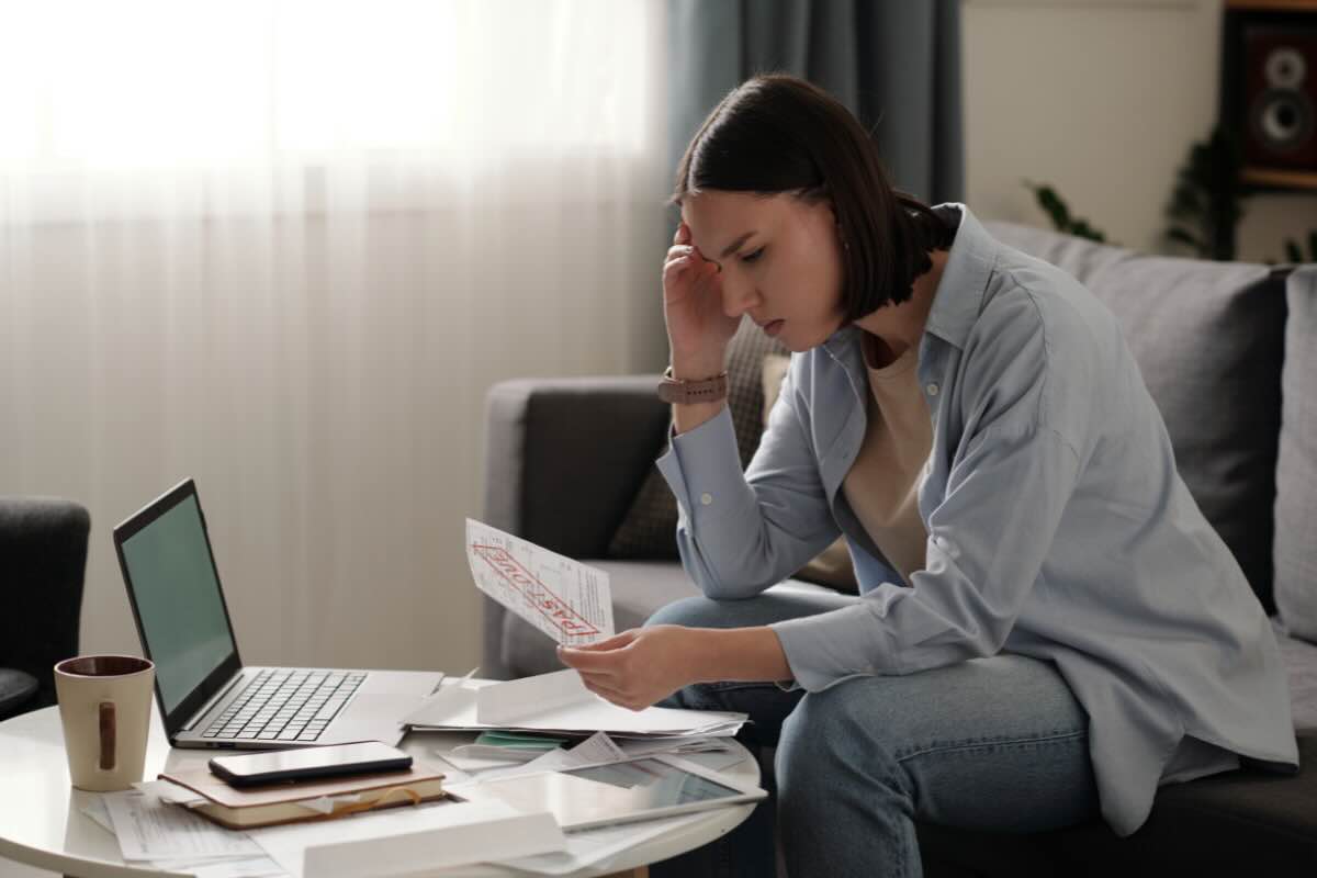 donna preoccupata che legge fogli