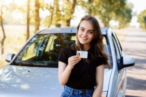 Ragazza con patente davanti auto