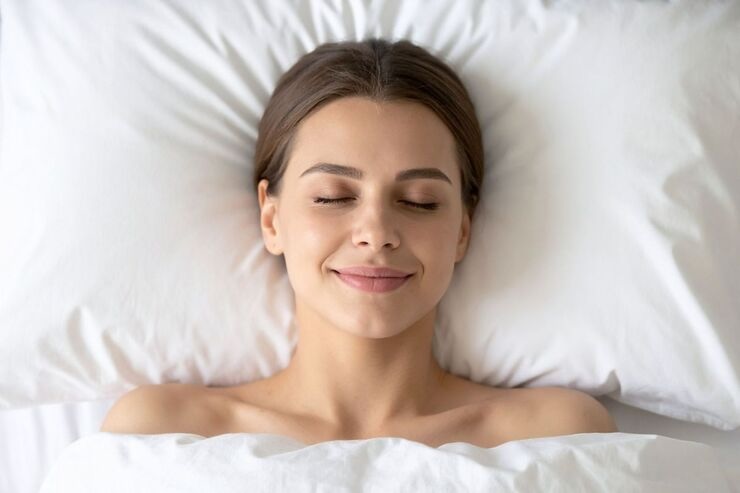 Ragazza nel letto sorridente con occhi chiusi