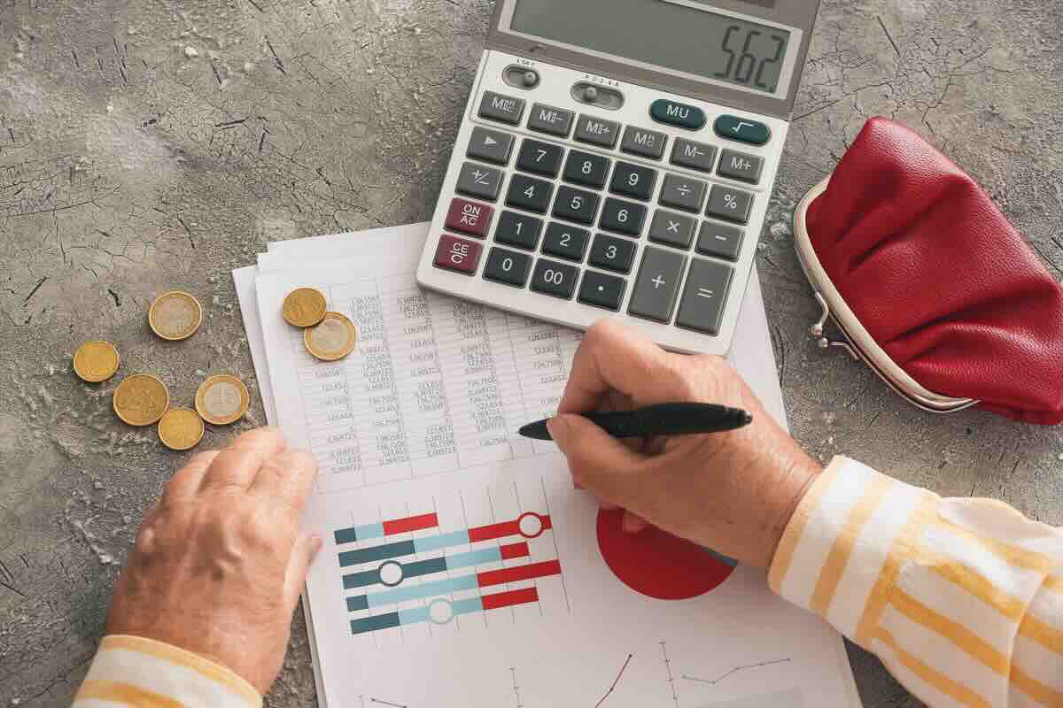 Scrivere su un foglio con grafici e conti, monete, calcolatrice