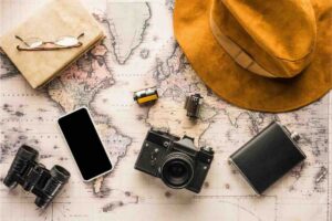 Cappello, diario, cellulare, macchina fotografica, mappa