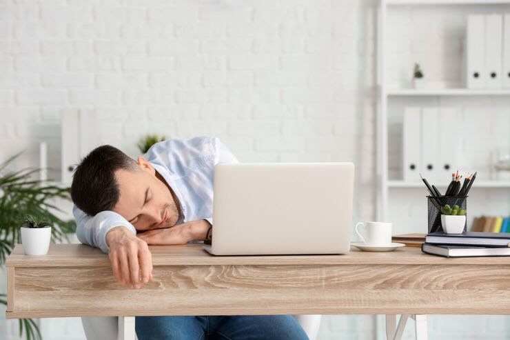 Uomo sulla scrivania accasciato, vicino al PC