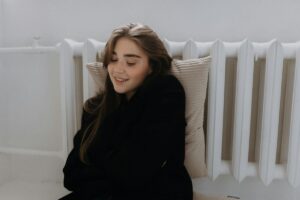 Ragazza al termosifone con cuscino