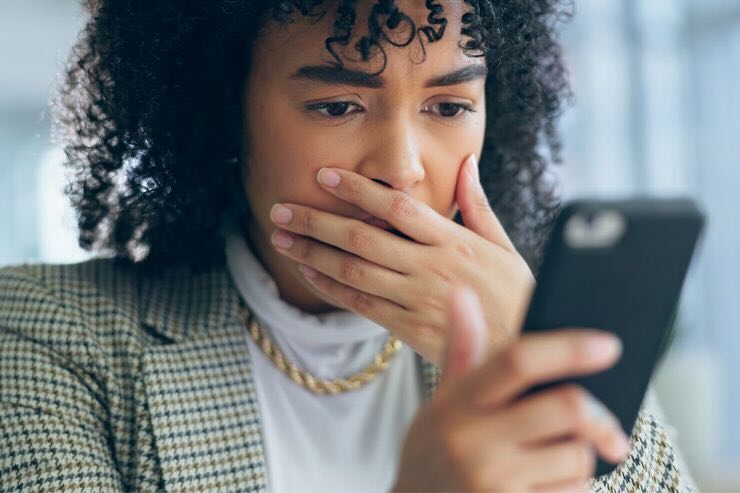 Donna sconvolta legge su smartphone 
