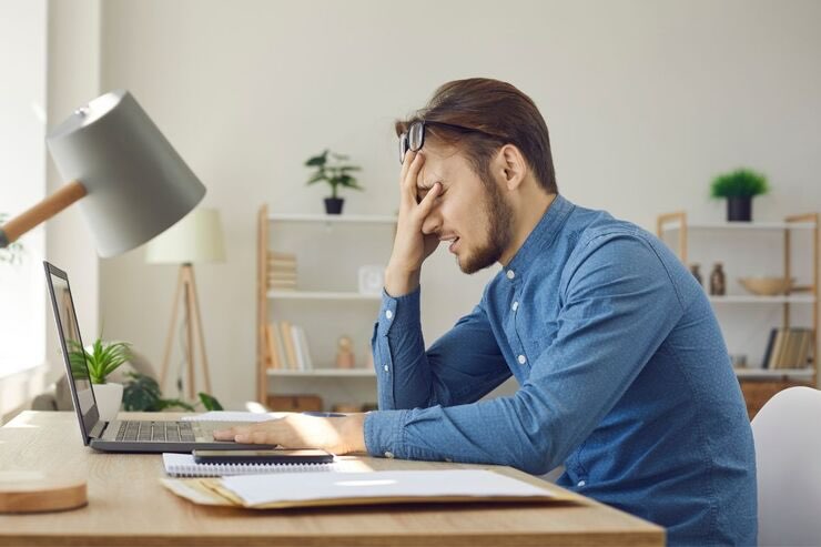 Ragazzo davanti al PC mano sul viso