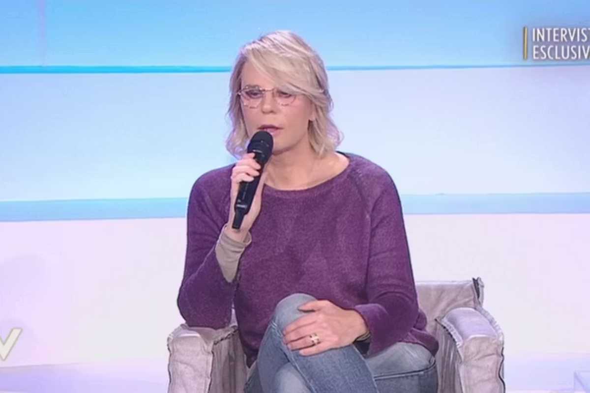 maria de filippi seduta al microfono
