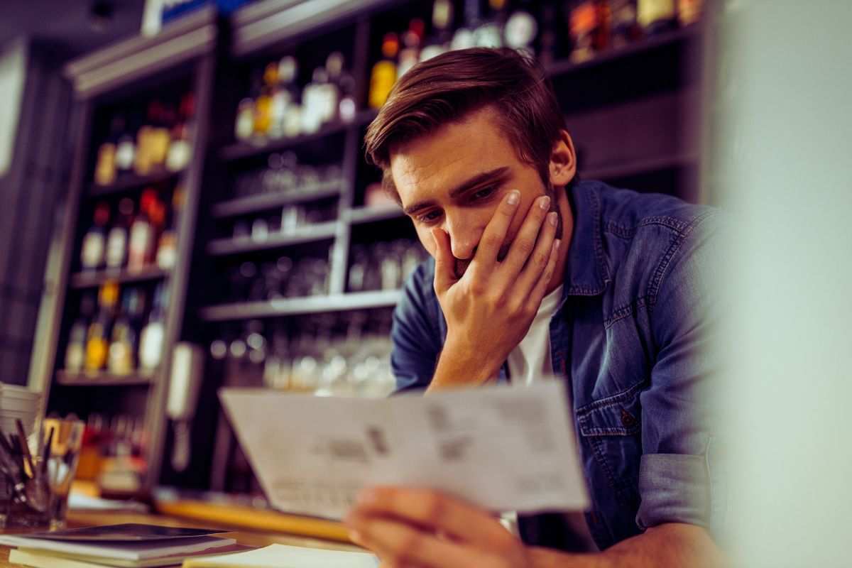 uomo sconvolto che legge carte