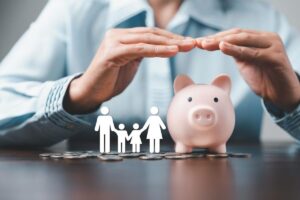 Mani su salvadanaio maiale, omini di carta